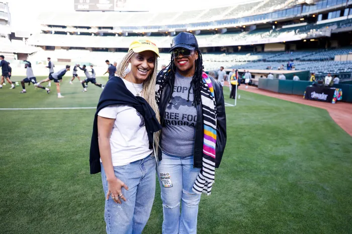 Akilah Cadet, co-propriétaire d'Oakland Roots SC, et l'écrivaine Thembisa Mshaka posent lors des échauffements avant un match.