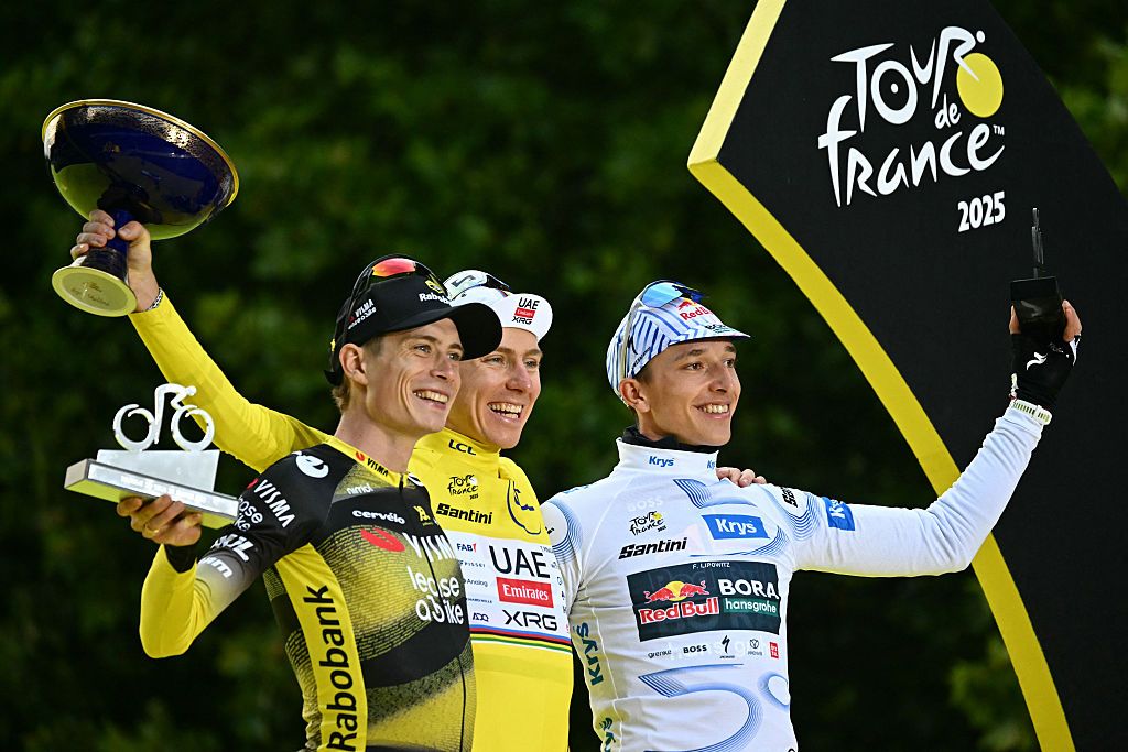 Overall winner UAE Team Emirates - XRG team's Slovenian rider Tadej Pogacar (C) wearing the overall leader's yellow jersey, second-placed Team Visma - Lease a bike team's Danish rider Jonas Vingegaard (L), and third-placed Red Bull - BORA - hansgrohe team's German rider Florian Lipowitz (R) celebrate on the podium after the 21st and final stage of the 112th edition of the Tour de France cycling race, 132.3 km between Mantes-la-Ville and Paris Champs-&Atilde;lysees, on July 27, 2025. (Photo by Loic VENANCE / AFP)
