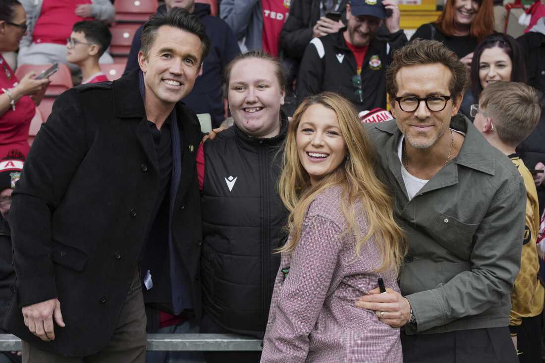Les copropriétaires de Wrexham, Ryan Reynolds (à droite), sa femme Blake Lively et Rob McElhenney posent avec des supporters avant le match de football de la Ligue anglaise entre Wrexham et Charlton Athletic au Racecourse, au Pays de Galles, le 26 avril 2025.