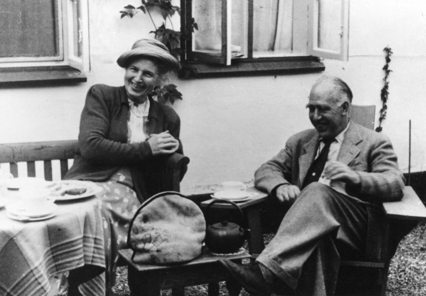 Margrethe assise à gauche à une table extérieure et Niels sur le côté à droite.