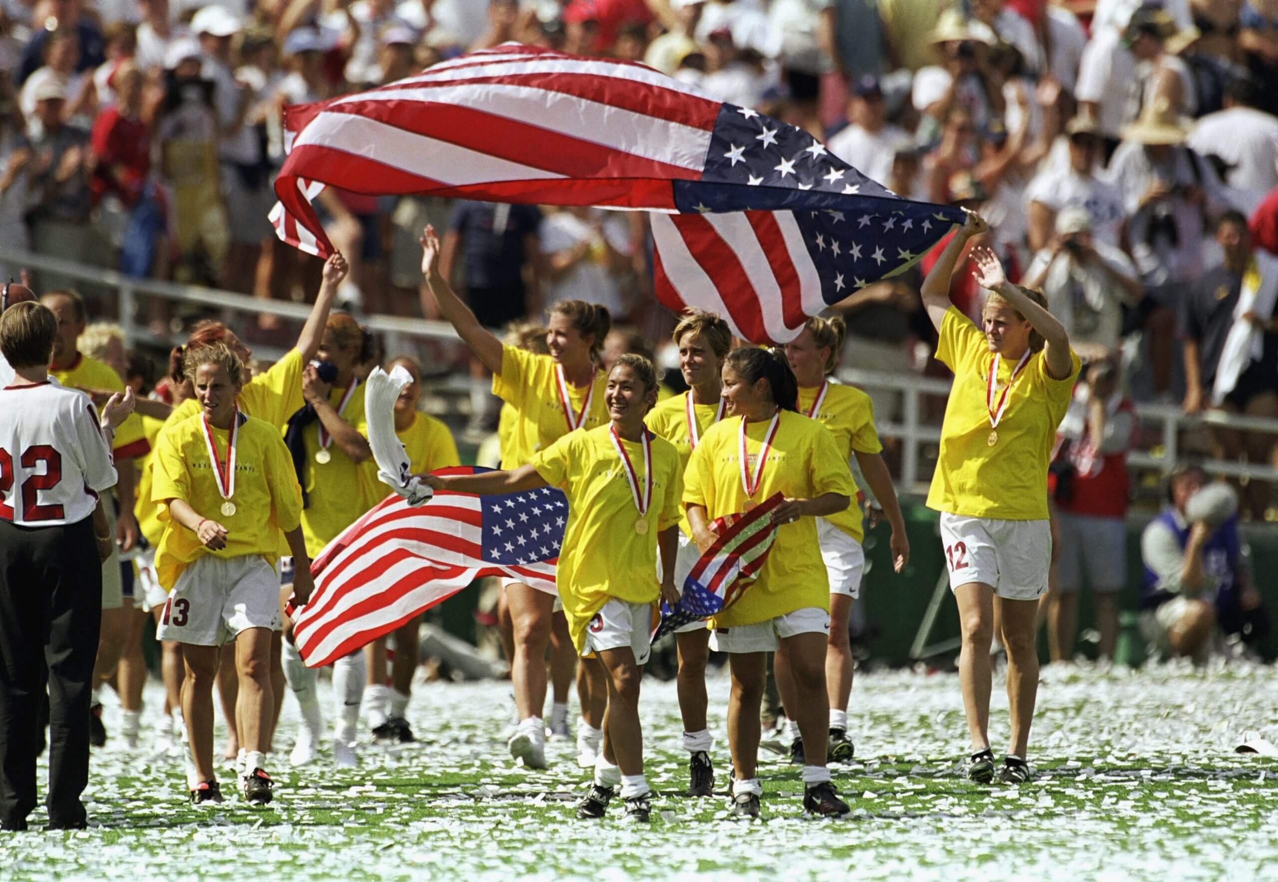 Des membres de l'équipe des États-Unis agitent des drapeaux américains en célébration de leur victoire contre l'équipe de Chine lors de la Coupe du Monde féminine de 1999.