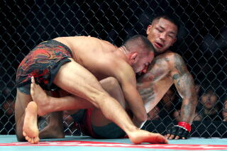 Alexandre Pantoja tente de maintenir Van au sol pendant leur combat UFC 331.