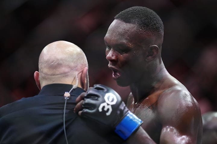 Israel Adesanya (gants bleus) réagit à sa victoire contre Alex Pereira (gants rouges) lors de l'UFC 287.