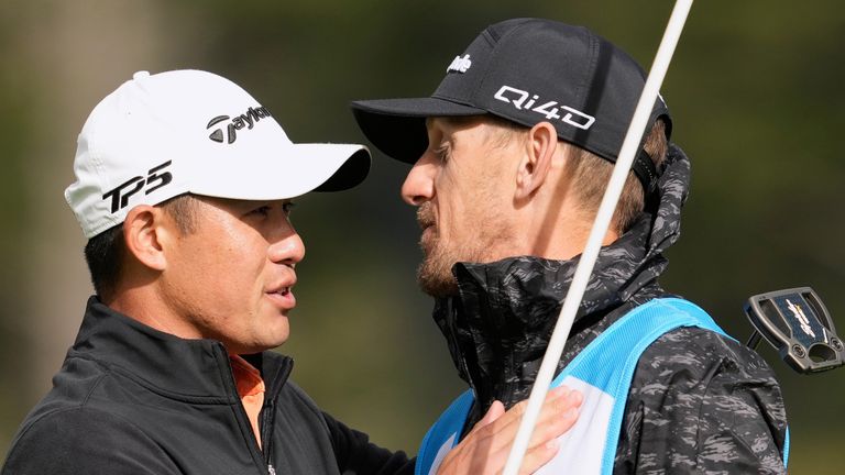 Collin Morikawa célèbre avec son caddie, Mark Urbanek, après avoir effectué un birdie au 18e trou.