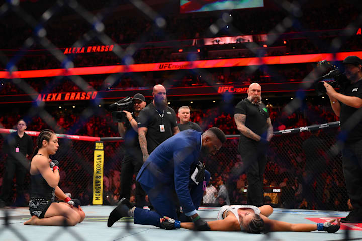 Alexa Grasso (gants rouges) attend que Maycee Barber (gants bleus) soit examinée par le personnel médical après leur affrontement à l'UFC.
